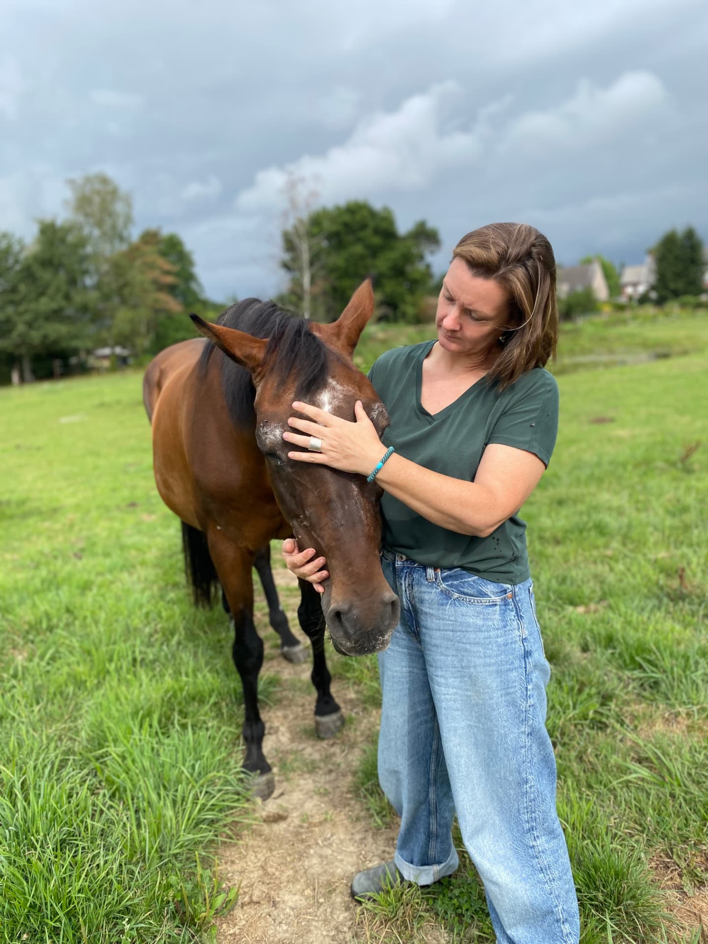 Laurence bij haar paard in de weide